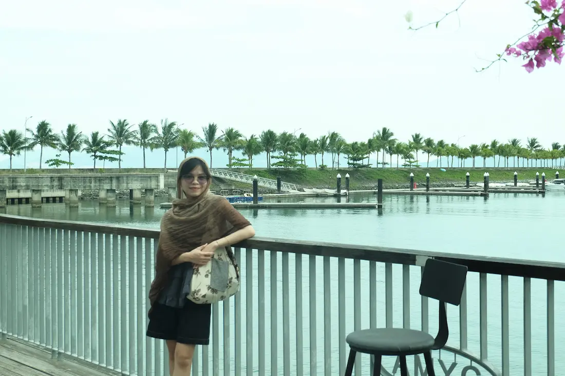 Cô gái Vy Vy trùm chiếc khăn màu nâu đứng giữa khung cảnh hữu tình